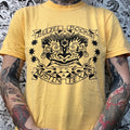 Front of a yellow t-shirt with a black screen printed belzel books logo on the front