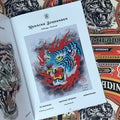 Inside pages of, 'Spitshading Tiger Heads', featuring a painting of a blue tiger head with red flames around it