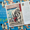 Inside pages of, 'Animals by Kuniyoshi', featuring a two giant elephants in a field, with a small child beside them and Japanese text at the top