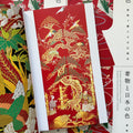 Inside pages of, 'Kimono and the Colors of Japan', featuring a red kimono with gold embroidery of a tree, bamboo, turtles, phoenix, and two people at the bottom of the tree