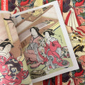 Inside pages of A Mirror of Yoshiwara Beauties by Katsukawa Shunsho featuring a painting of two ladies in elegant attire.