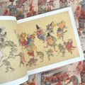 Inside pages of Kyosai featuring colorful frogs, bats, and other animals wearing traditional Japanese attire whole dancing and playing instruments.