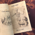 Inside pages of Devises featuring a hand holding a skeleton in a funnel captioned with Latin script.
