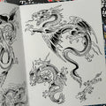 Inside pages of Don Ed Hardy's Dragon Tattoo Design book featuring black and white dragon designs.