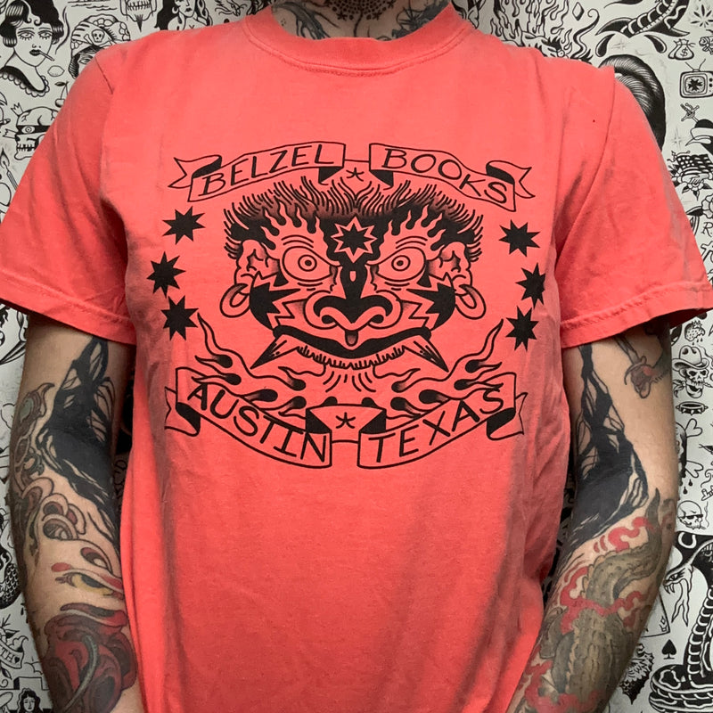 Front of a salmon colored t-shirt, with a black screenprinted belzel books logo on the front