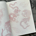 Inside pages of Garyotensei featuring two full bodied dragons moving in different directions, one with wings, and one with flames around it. Decorative flames are in the background as well  