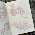 Inside pages of Garyotensei featuring sketches of dragon heads, one with a closed mouth and one with an open mouth.