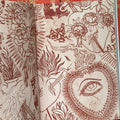 Inside pages of 'Sagrado' by Carlos Truan and Zac Scheinbaum featuring a collage of Sacred Heart stencils in red ink.