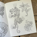 Inside pages of Line Drawings by Chris Stuart featuring various line drawings done in the traditional style, including a tribal-style panther, a rose, and a cross with a crying eye.