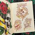 Inside pages of Keep It Real by Rinto featuring sketches and a full color drawing of skulls and roses with baners.