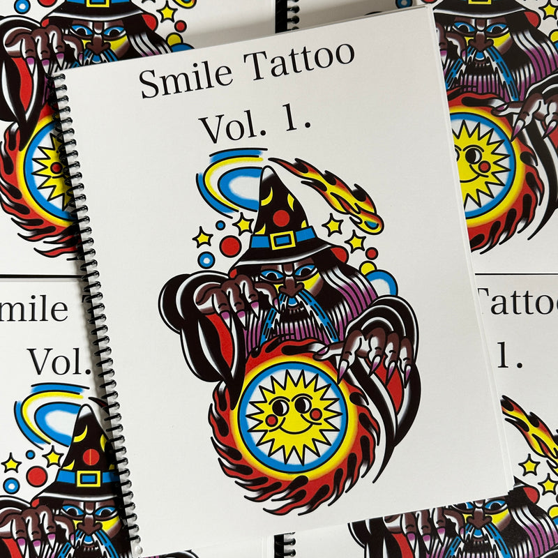 Front cover of Smile Tattoo Vol. 1 featuring a traditional style color image of a wizard conjuring a fireball with a smiley sun in the center.