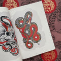 Inside pages of Drawing for Tattoos Vol. 1 by Chris O'Donnell featuring a color drawing of a snake with red underbelly and intricate black and white pattern.