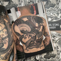 Inside pages of Traditional Icons by Rich Hardy featuring a photograph of a finished back piece of a "Battle Royale" in black and grey.