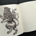 Inside pages of OG Abel Sketchbook featuring a sketch of a lion wearing a crown.