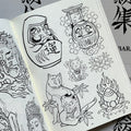  Inside pages of Japanese Tattoo Outlines by Leo Barada featuring line drawings of various Japanese subjects such as Daruma, a Daruma doll, a maneki neko (lucky cat), a peony, a cat tattooed with a hannya, and a Hoju. 