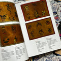 Inside pages of The Tattoo Catalogue 2024 featuring vintage tattoo flash sheets depicting a range of traditional imagery including skulls and military motifs.