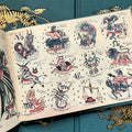 Inside pages featuring the zodiac signs depicted as traditional tattoo flash with star fillers in the background.