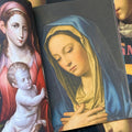 Inside pages of 'Virgin Mary', featuring the Virgin Mary crossing her hands over her chest and looking down, while wearing a blue cloak and a yellow robe