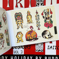 Inside pages of Buddy Holiday Tiki Tattoo Designs Vol 3, featuring tiki figures, a flamingo in a pond, a skull, and a tower of skulls with a spear through them.