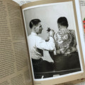 Inside pages of, 'Tattoo', featuring a photo of a man tattooing another man's shoulder, who has a giant back piece of a tiger with flowers around it