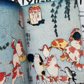 Inside pages of, 'Cats in Ukiyo-e', featuring a pack of koi fish walking together holding each others fins, with a tadpole and also holding fans