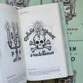 Inside pages of, 'Russian Criminal Tattoo Vol. 2', featuring a skull with a burning candle on it's head, a question mark on it's forehead, and russian text above and below it