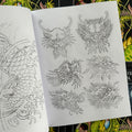 Inside pages of The Dragon Sketchbook by Erik Rieth, a line drawings and sketches tattoo book, featuring six dragon heads with different expressions and designs.