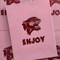 Front cover of Austin Maples, 'Enjoy', featuring a pink background with a hot pink embossed panther head and the word Enjoy, on a clear white cover