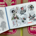 Inside pages of, 'Neon Moon Tattoo', featuring drawings on vellum of a dancing lady, a frog, skulls, and stars.