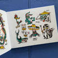 Traditional tattoo flash sheet from 'Everything That Burned' tattoo book by Jeff P. of old-school characters including a duck, shark, skunk, rabbit, roadrunner, and other designs.