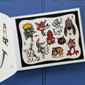 Traditional tattoo flash sheet from 'Everything That Burned' tattoo book by Jeff P. with cartoon cats, dogs, a wolf, and a rabbit.