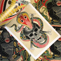 Inside pages of Chris Marchetto Art featuring a depiction of a cobra emerging from a skull and crossbones rendered in traditional style and colors.