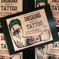 Front cover of Designs Ready to Tattoo Vol. 1 by Wyatt Howland featuring an image of an arm with traditional tattoos on it.