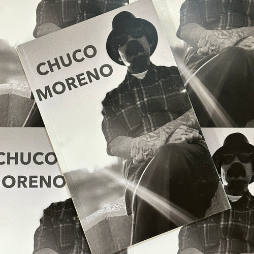 Front cover of Chuco Moreno Book featuring a portrait of Chuco sitting down with his arms crossed on the cover.