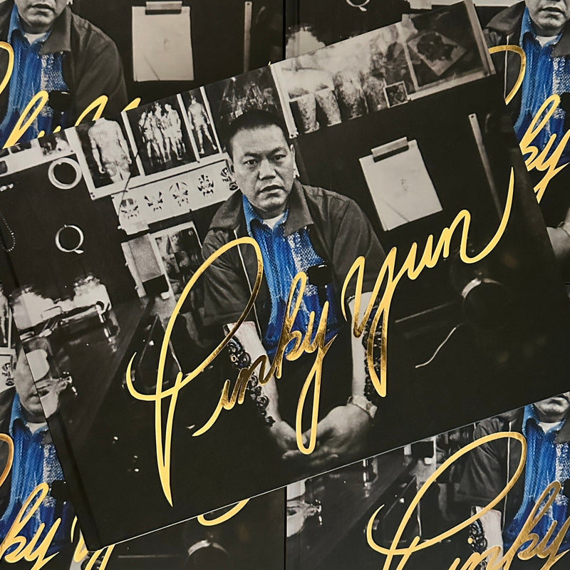 Front cover of Tattoo Master Pinky Yun: The Don Ed Hardy Collection featuring a portrait of Pinky Yun and his signature in gold lettering.