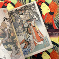 Inside pages of Kunisada featuring a color woodblock print of a lady with beautiful and intricate attire posing next to a tree.