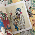 Inside pages of Sheng Dan Jing Chou featuring a color painting of traditional Chinese performance attire and masks.