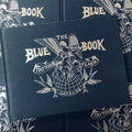 Front cover of The Blue Book featuring angel and birds in silver on a dark blue hard cover book.
