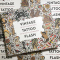 Front cover of Vintage Tattoo Flash Volume I featuring a variety of full color tattoo flash on a white cover.