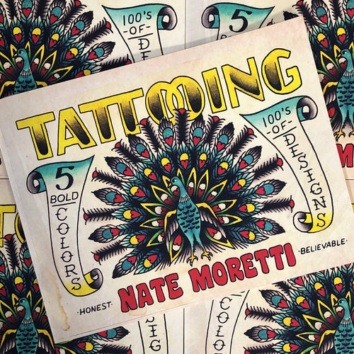 Front cover of Nate Moretti - Traditional Tattoo Flash featuring bold lettering and an American traditional depiction of a peacock in five colors on a light background and a soft bound cover.