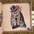 Inside page of Front cover of Jonathan Shaw's - Vintage Tattoo Flash Collection: Skulls Vol.1 showcasing a skull in front of a sun. Dressed in a cape and top hat. Holding a candle with one hand and pointing with the other. 